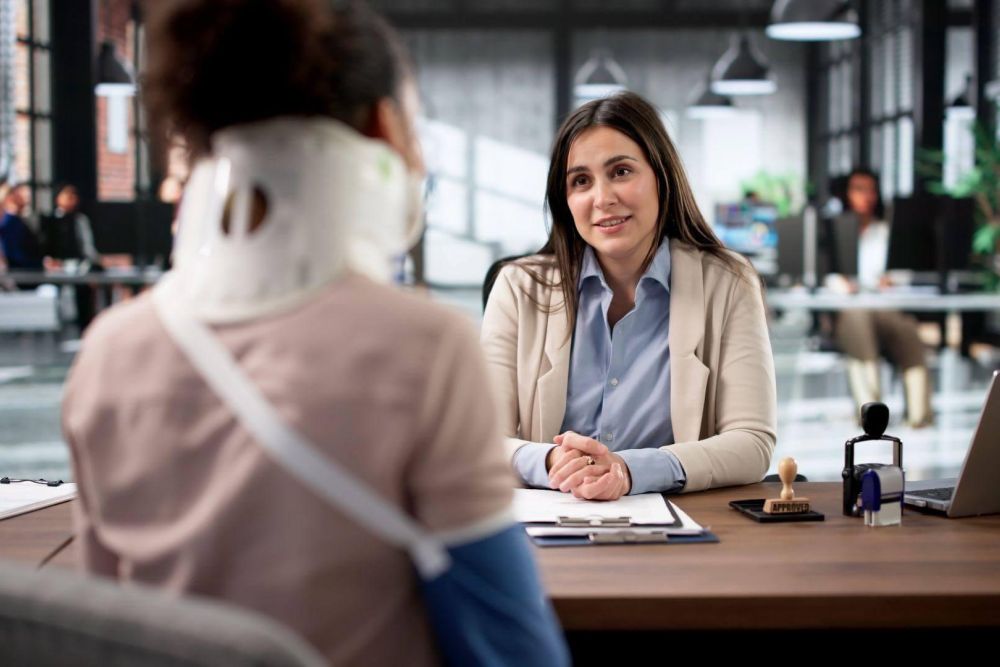 a woman sitting at a desk talking to another woman