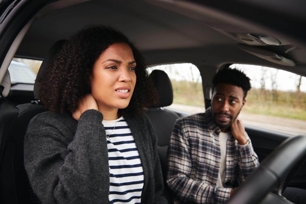 a man and a woman sitting in a car