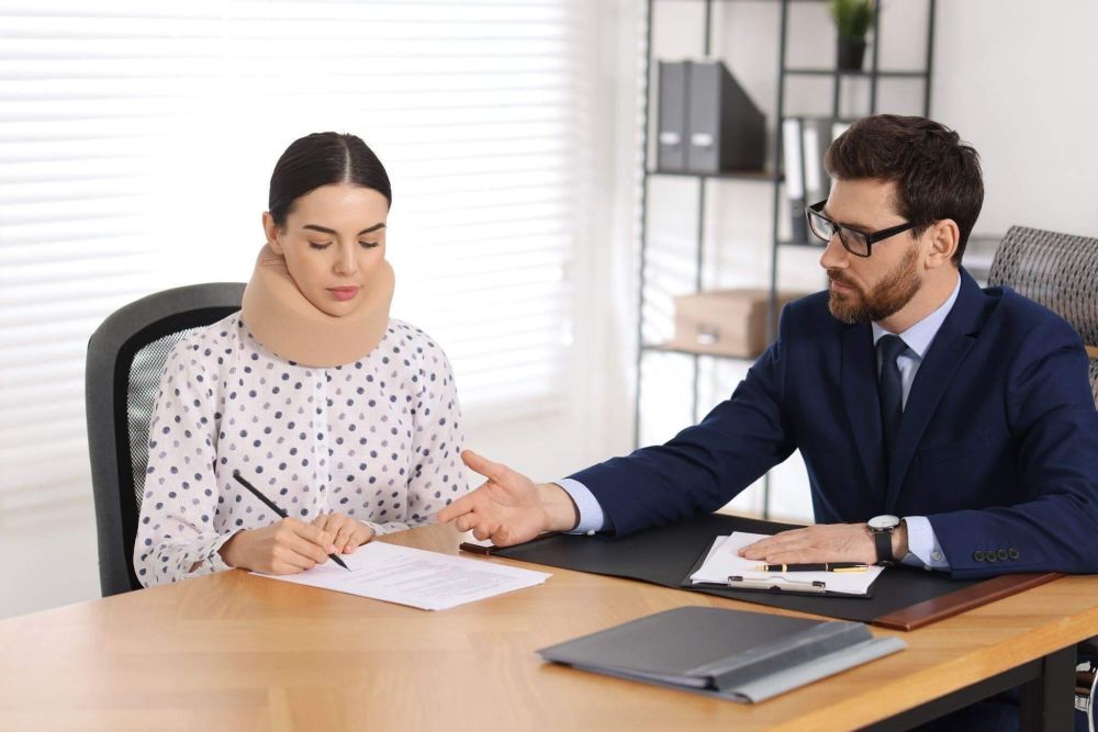a man and a woman sitting at a desk and reviewing a legal document