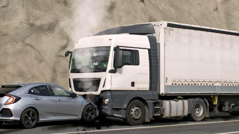 A car positioned in front of a tractor-trailer