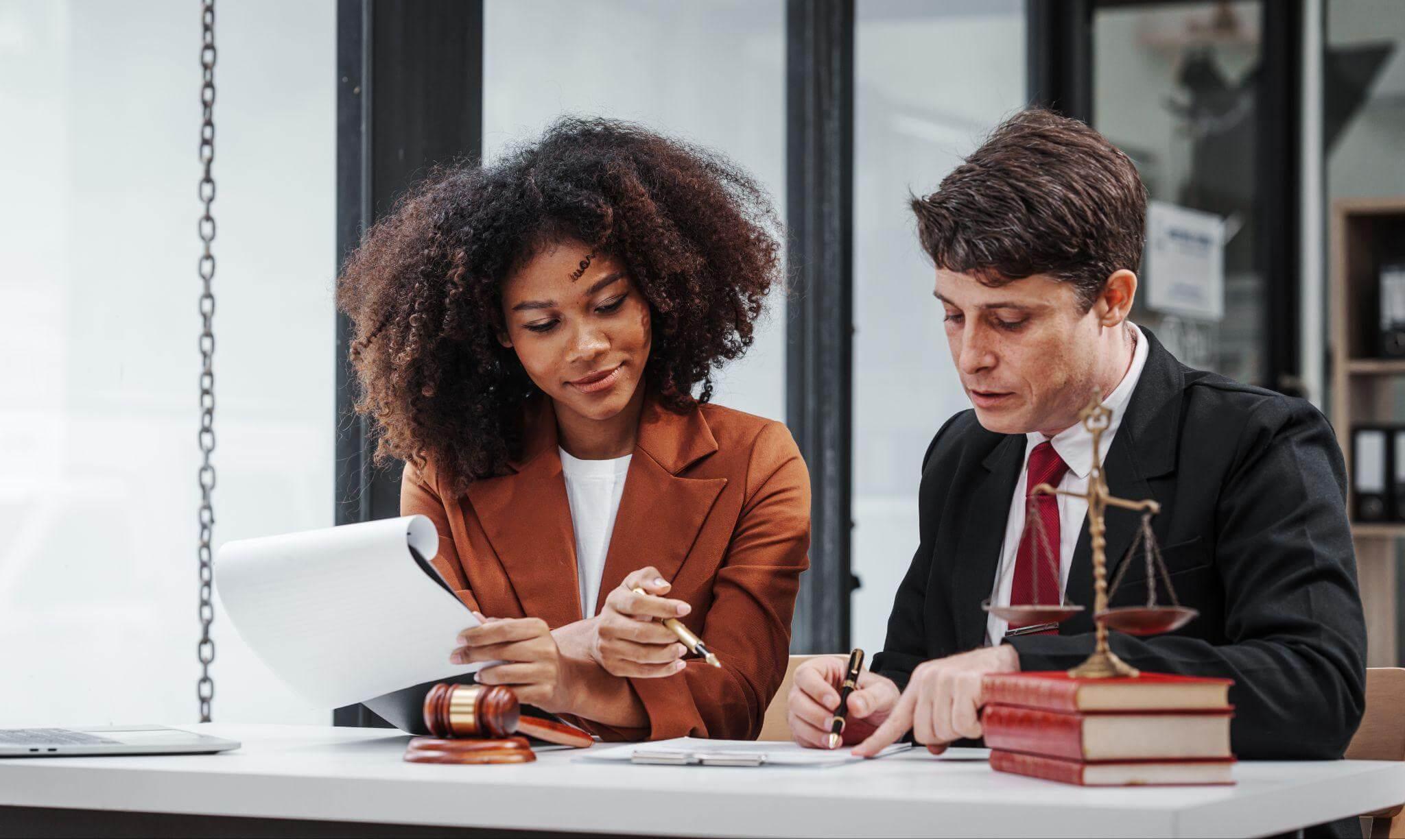 a couple of people that are sitting at a table reviewing legal documents