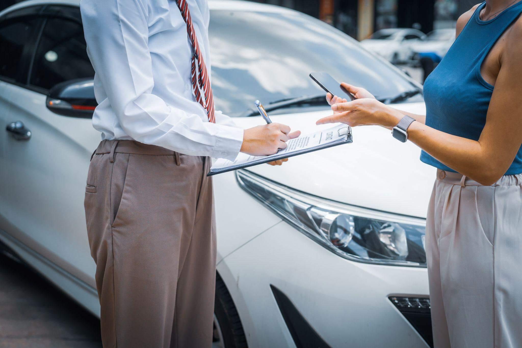 a man and a woman standing in front of a car