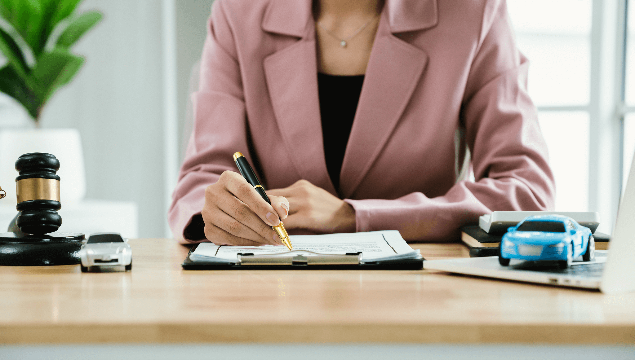 a woman sitting at a desk with a pen in her hand