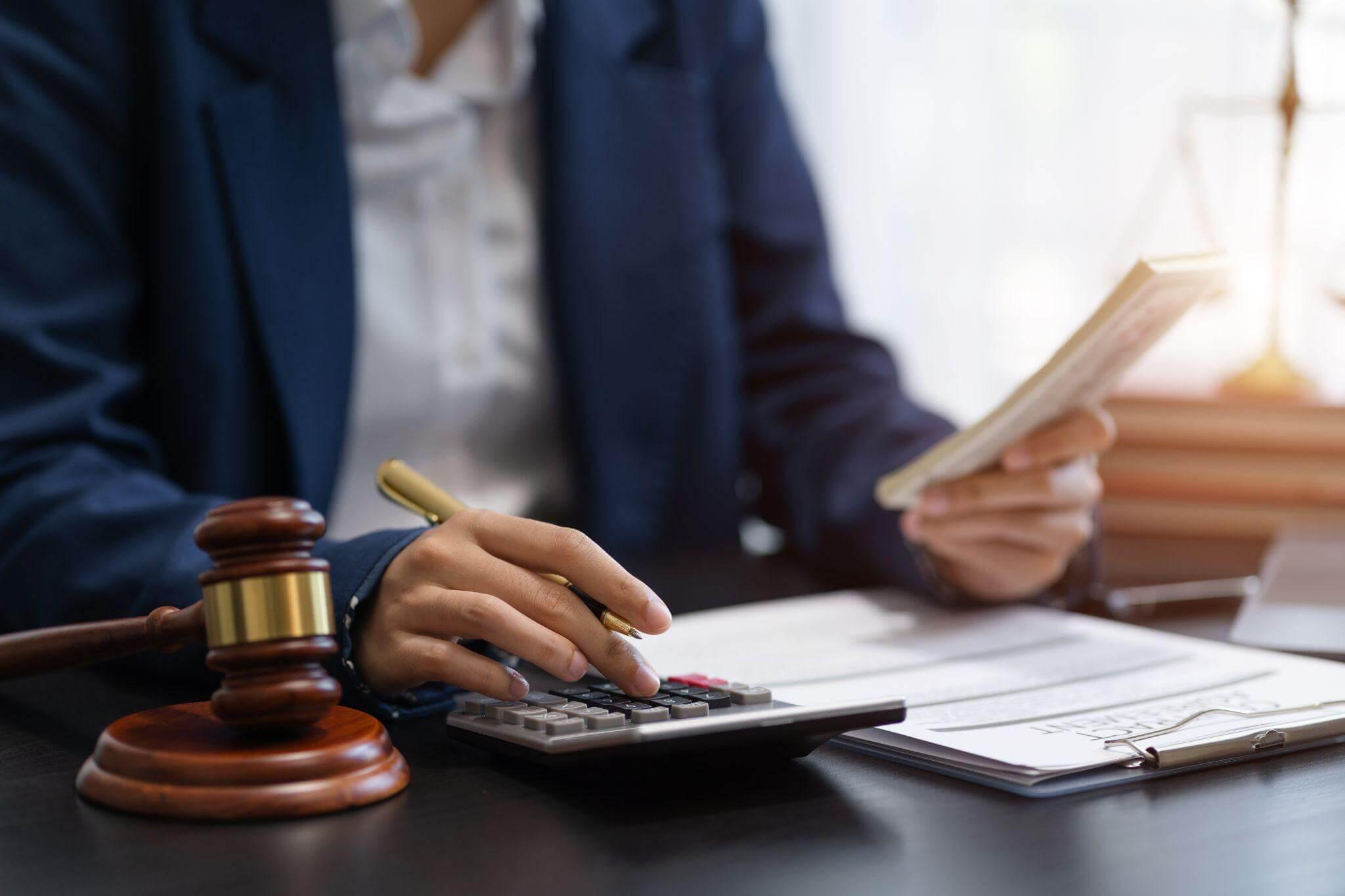 a person sitting at a desk with a calculator and a book